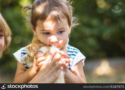 Girls play with kitten outdoor in the park
