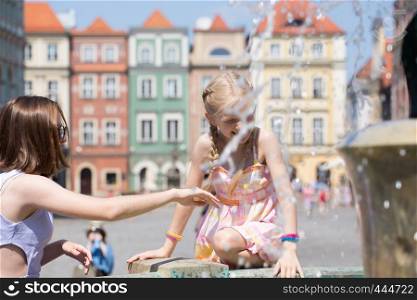 girls playing at the fountain on a Poznan main square