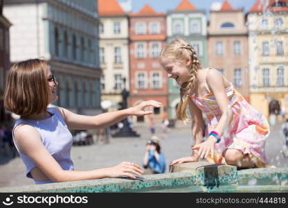 girls playing at the fountain on a Poznan main square