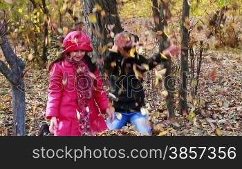 Girls playing in Autumn with leaves