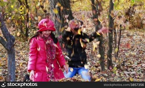 Girls playing in Autumn with leaves
