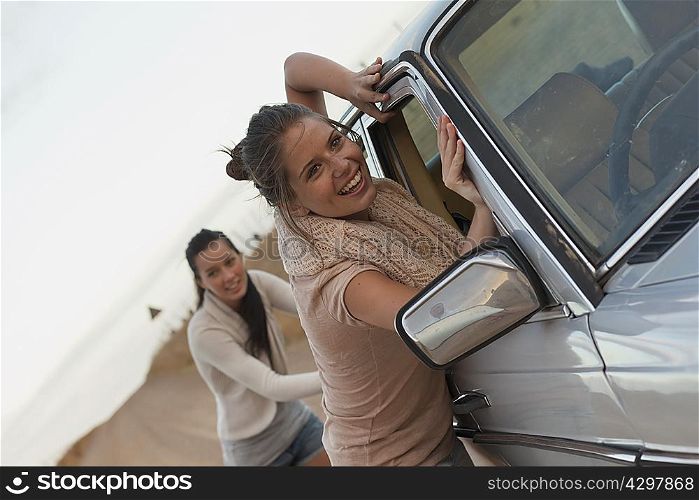 Girls pushing car