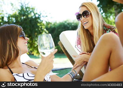 Girls relaxing by the pool on sun beds