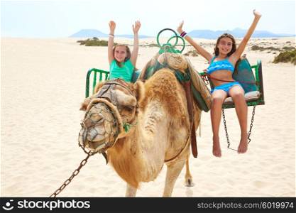 Girls riding Camel in Fuerteventura desert at Canary Islands of Spain