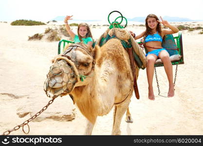 Girls riding Camel in Fuerteventura desert at Canary Islands of Spain