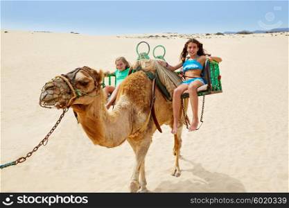 Girls riding Camel in Fuerteventura desert at Canary Islands of Spain