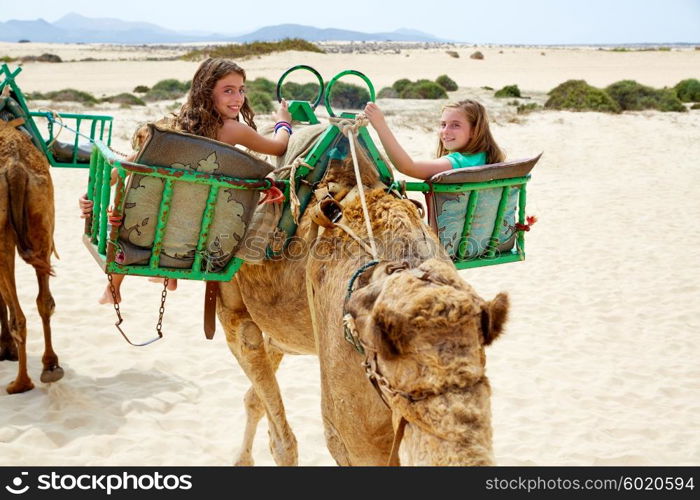 Girls riding Camel in Fuerteventura desert at Canary Islands of Spain