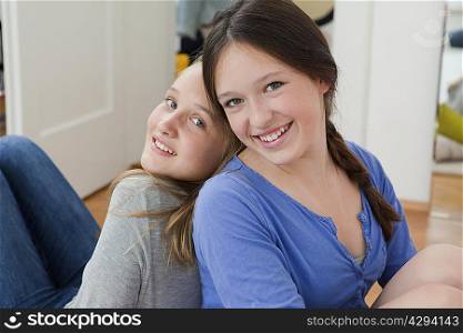 Girls sitting together in bedroom