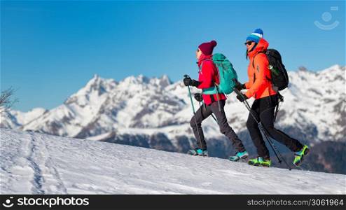 Girls walk with crampons on the snow in the mountains
