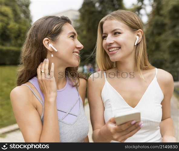 girls wearing airpods park
