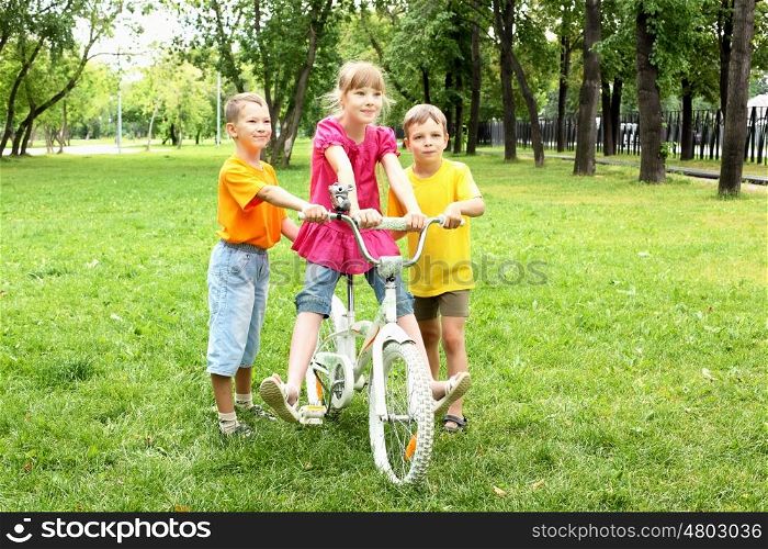 Girls with a bike in the summer park