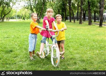 Girls with a bike in the summer park