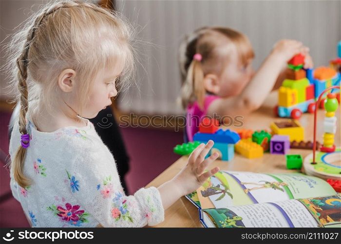 girls with book colorful toys