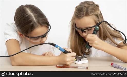 girls with protective glasses doing science experiments