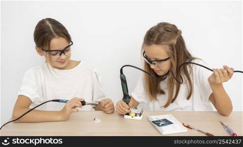 girls with protective glasses doing science experiments together