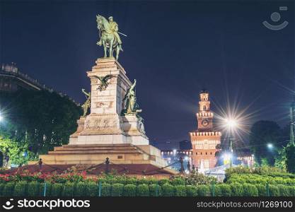 Giuseppe Garibaldi Monument in Milan, Italy and Sforza Castle (Castello Sforzesco) at night. They is the famous travel destination for tourist visiting Milan, Italy.