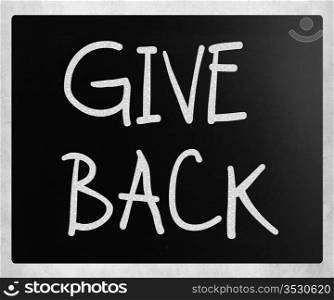 ""Give back" handwritten with white chalk on a blackboard."