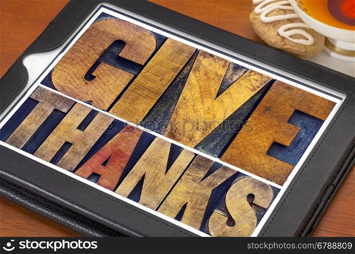 Give thanks - Thanksgiving concept - text in vintage letterpress printing blocks on a digital tablet with cup of tea and cookie