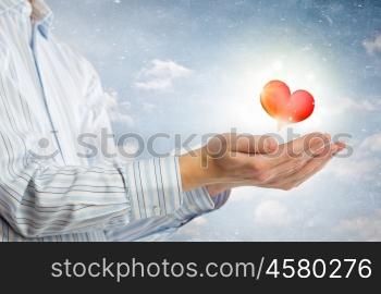 Giving love. Close up of hands holding red heart