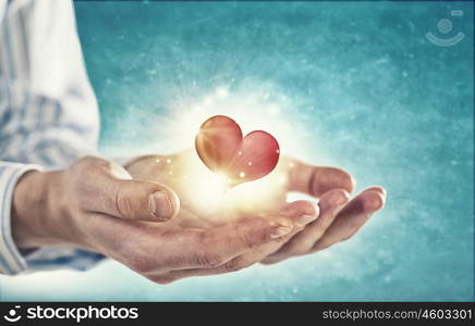 Giving love. Close up of hands holding red heart