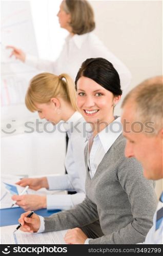Giving presentation young executive during meeting woman pointing at flip-chart