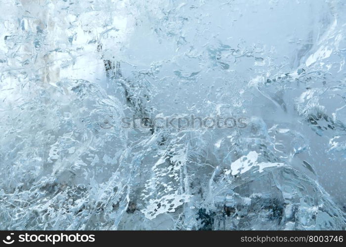 Glacial transparent block of ice (close up) with interesting drawings and patterns. Background.