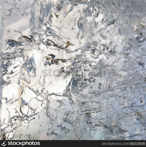 Glacial transparent block of ice with interesting drawings and patterns