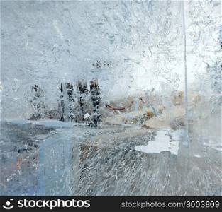 Glacial transparent wall of ice with interesting drawings and patterns and silhouette of room behind. Closeup, background.