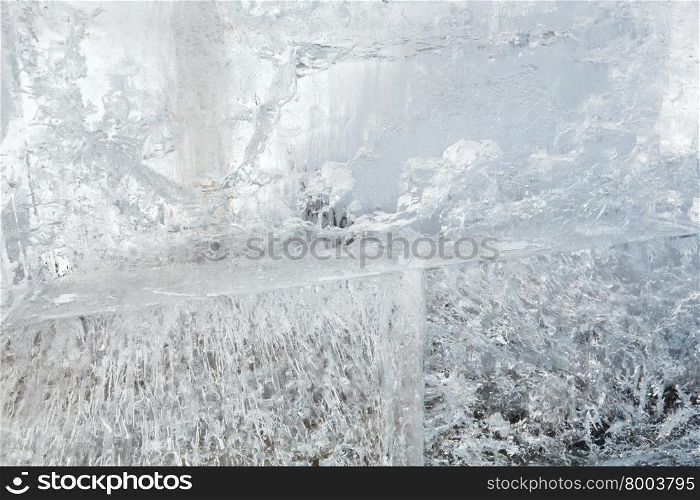 Glacial transparent wall of ice with interesting drawings and patterns . Closeup, background.