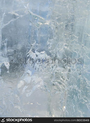 Glacial transparent wall of ice with interesting drawings and patterns . Closeup, background.