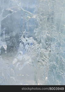 Glacial transparent wall of ice with interesting drawings and patterns . Closeup, background.