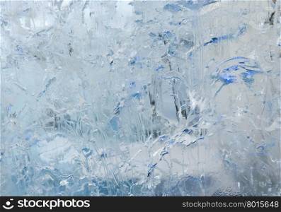 Glacial transparent wall of ice with interesting drawings and patterns. Winter background.