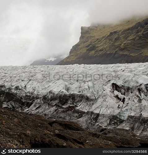 Glacier in cloudy mountain valley