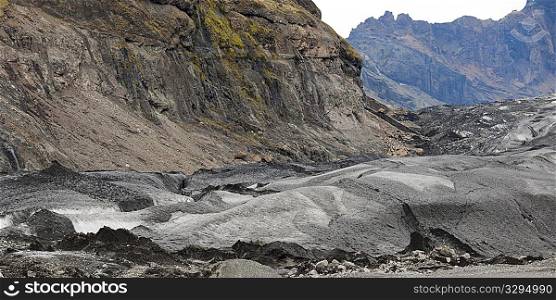 Glacier moraine and debris, rocks ground into glacial flour, in craggy mountains