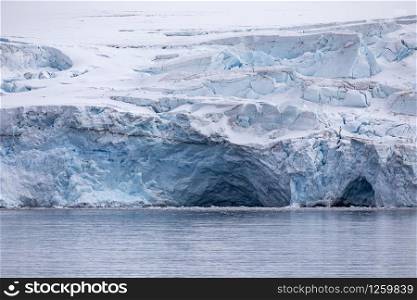 Glacier with blue colored vault and ice cave in Antarctica