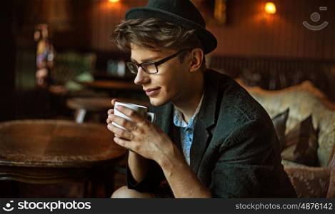 Glad elegant guy drinking a coffee