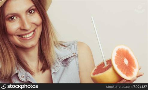 Glad woman in hat holding grapefruit. Happy glad woman tourist in straw hat holding grapefruit citrus fruit. Healthy diet food. Summer vacation holidays concept.
