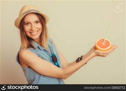 Glad woman in hat with sunglasses and grapefruit. Happy glad woman tourist in straw hat with sunglasses and grapefruit citrus fruit. Healthy diet food. Summer vacation holidays concept. Instagram filtered.
