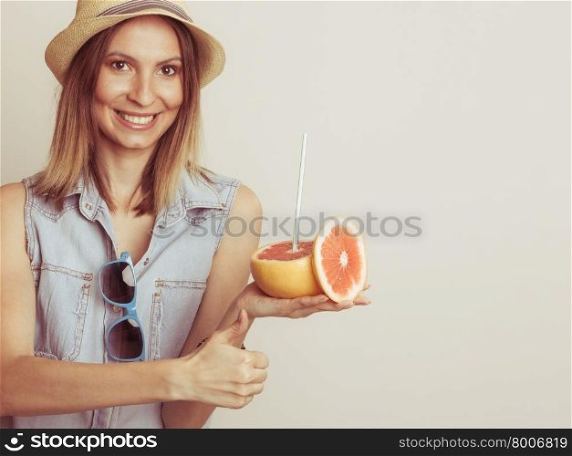 Glad woman in hat with sunglasses and grapefruit. Happy glad woman tourist in straw hat with sunglasses and grapefruit citrus fruit giving thumb up. Healthy diet food. Summer vacation holidays concept.
