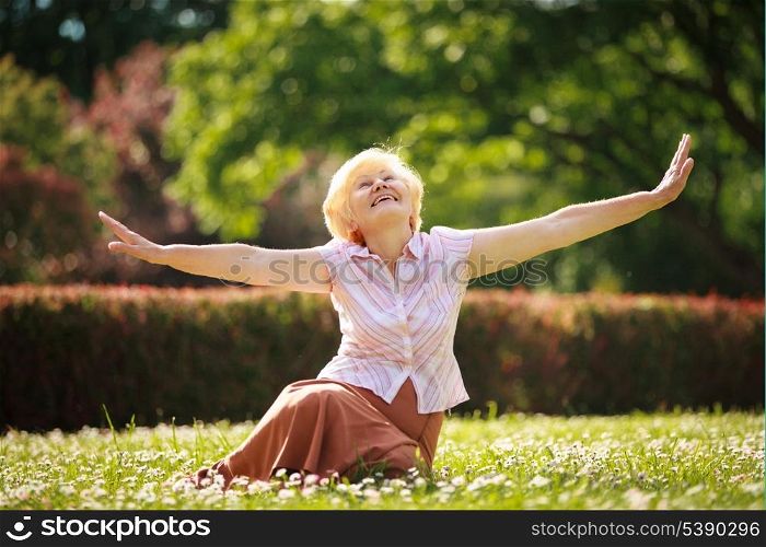 Gladness. Meditation. Mature Pleased Woman Relaxing with Outspread Arms