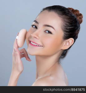 Glamorous beautiful female model applying cushion powder for facial makeup concept. Portrait of flawless perfect cosmetic skin woman put powder puff on her face in isolated background.. Glamorous beautiful female model applying powder puff for facial makeup concept.