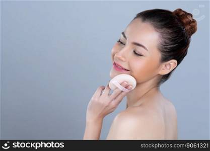 Glamorous beautiful female model applying cushion powder for facial makeup concept. Portrait of flawless perfect cosmetic skin woman put powder puff on her face in isolated background.. Glamorous beautiful female model applying powder puff for facial makeup concept.
