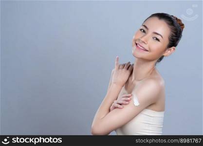 Glamorous beautiful woman applying moisturizer cream on her arm for perfect skincare treatment in isolated background. Soft makeup young girl portrait with skin rejuvenation and cosmetology concept.. Glamorous beautiful woman applying moisturizer cream on her arm for perfect skin