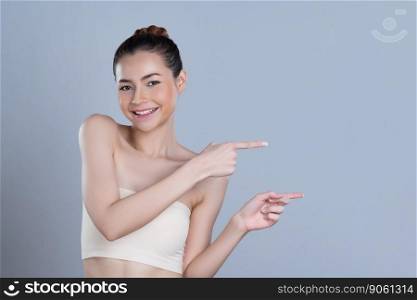 Glamorous beautiful woman with perfect makeup clean skin pointing finger in copyspace isolated background. Promotion indicated by hand gesture concept for skincare product advertisement.. Glamorous woman pointing finger advertising product in isolated background.