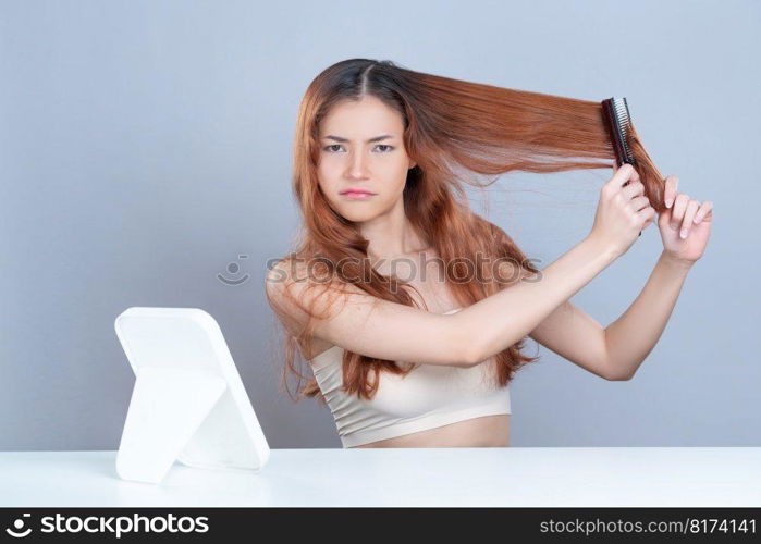 Glamorous beauty fresh clean skin woman having brittle dry hair problem. Grimacing frustrated sad facial expression. Concept of damaged hair loss by female model in isolated background.. Glamorous woman with cosmetic skin having dry hair loss problem .