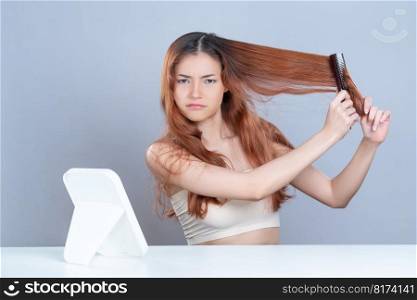 Glamorous beauty fresh clean skin woman having brittle dry hair problem. Grimacing frustrated sad facial expression. Concept of damaged hair loss by female model in isolated background.. Glamorous woman with cosmetic skin having dry hair loss problem .