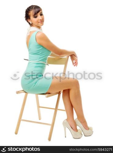 Glamorous girl in turquoise dress sit on chair isolated