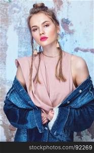 Glamorous girl with bright pink lips wearing rough denim jacket and delicate silk top