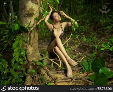 Glamorous lady in a lace leotard in a tropical forest