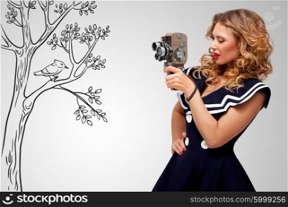 Glamorous pin-up sailor girl filming nature and wildlife with an old retro cinema 8 mm camera, standing in front of a bird on grey sketchy background.